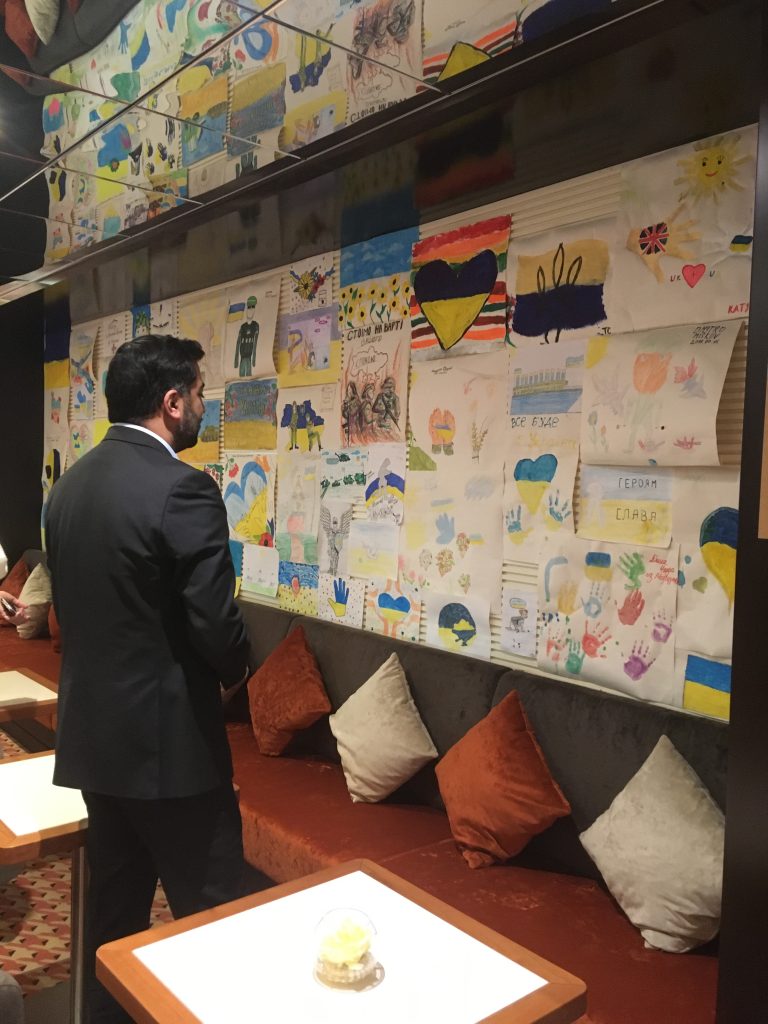 Humza Yousaf MSP on board MS Ambition, looking at artwork created by the children on board. 